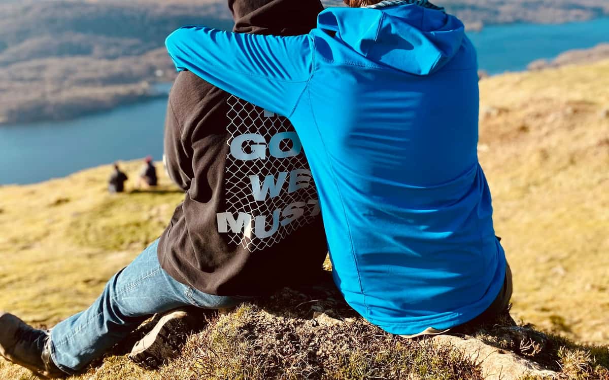 Stock photo: two men sitting together on a hillside overlooking a UK lake